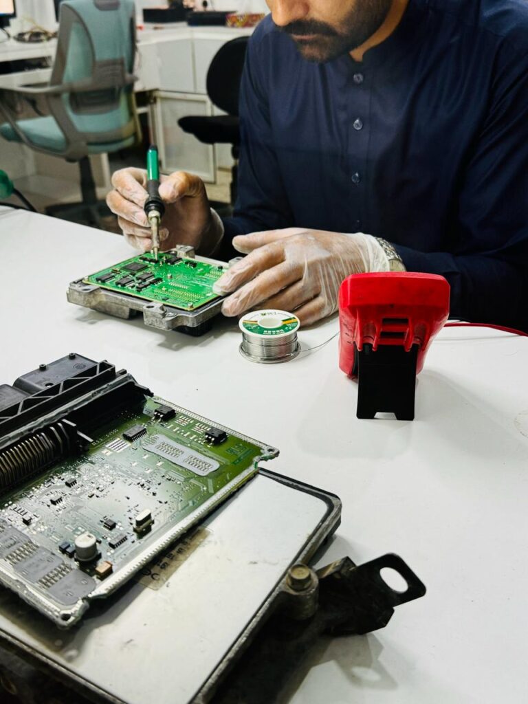 Technician Reparing ECU Electric Control Unit at Rashid Auto Programming Shop